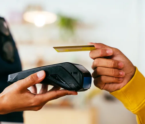 Close-up of an electronic transaction using a card reader and a credit card, illustrating the international payment collection and secure e-commerce payment services offered by Ágilex from Colombia to Mexico and the rest of the world.
