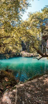 An oasis of turquoise water surrounded by lush vegetation bathed in sunlight, symbolizing the peace of mind that Ágilex’s international collection and secure payment services provide to tourism businesses that export their services to Mexico and around the world from Colombia.